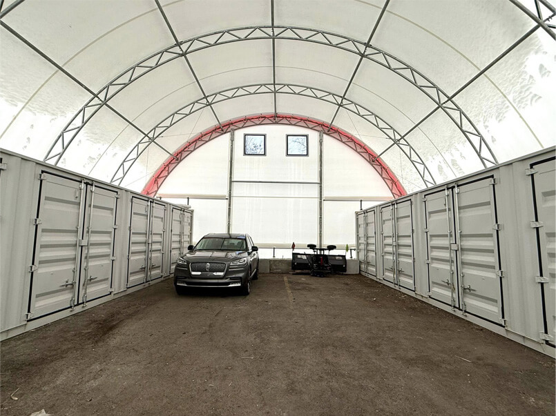 Intérieur d’un bâtiment en toile avec charpente d’acier galvanisé servant à l’entreposage de véhicules et conteneurs